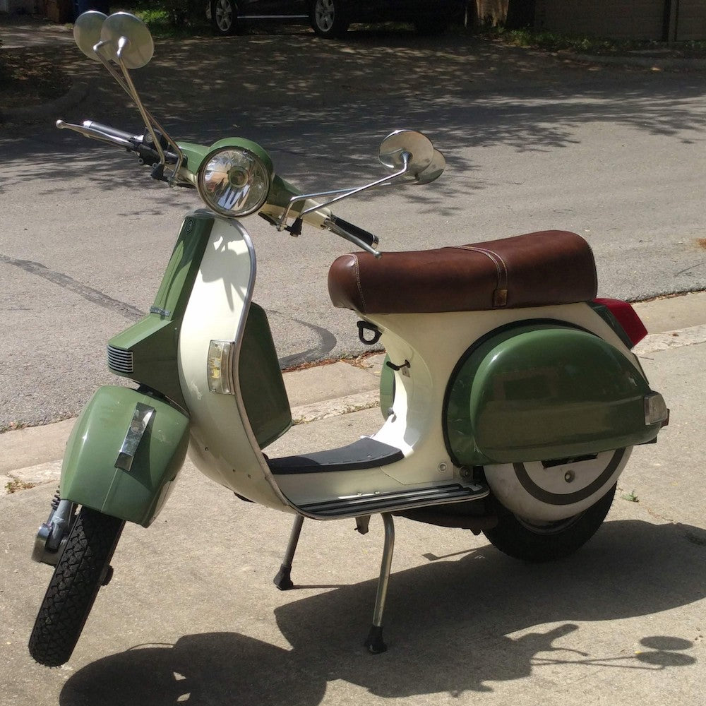Green and cream Genuine Stella scooter with a tailored whiskey-brown seat cover and matching strap, handmade by Cheeky Seats