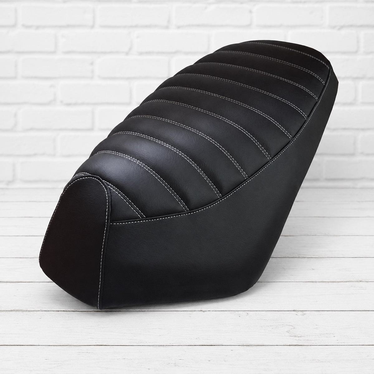 Black padded tuck-and-roll seat cover for Genuine Roughhouse with white stitching, handmade by Cheeky Seats
