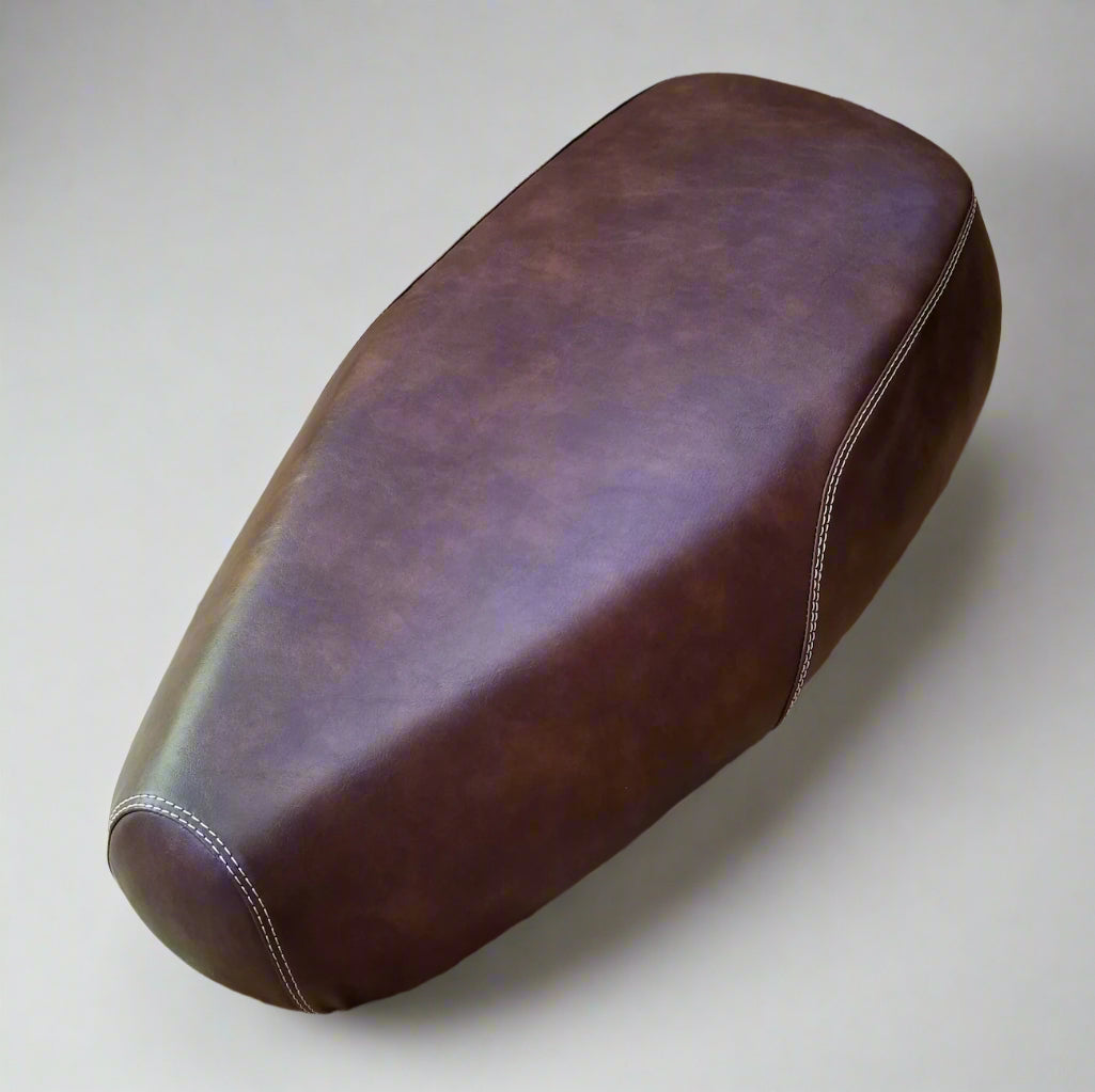 Distressed whiskey brown Genuine Buddy Kick 125 seat cover with contrasting double stitching and no piping, handmade by Cheeky Seats