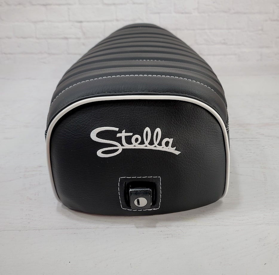 Rear close-up of a black Cheeky Seats tuck-and-roll cover showing white piping, Stella embroidery, and the lock opening