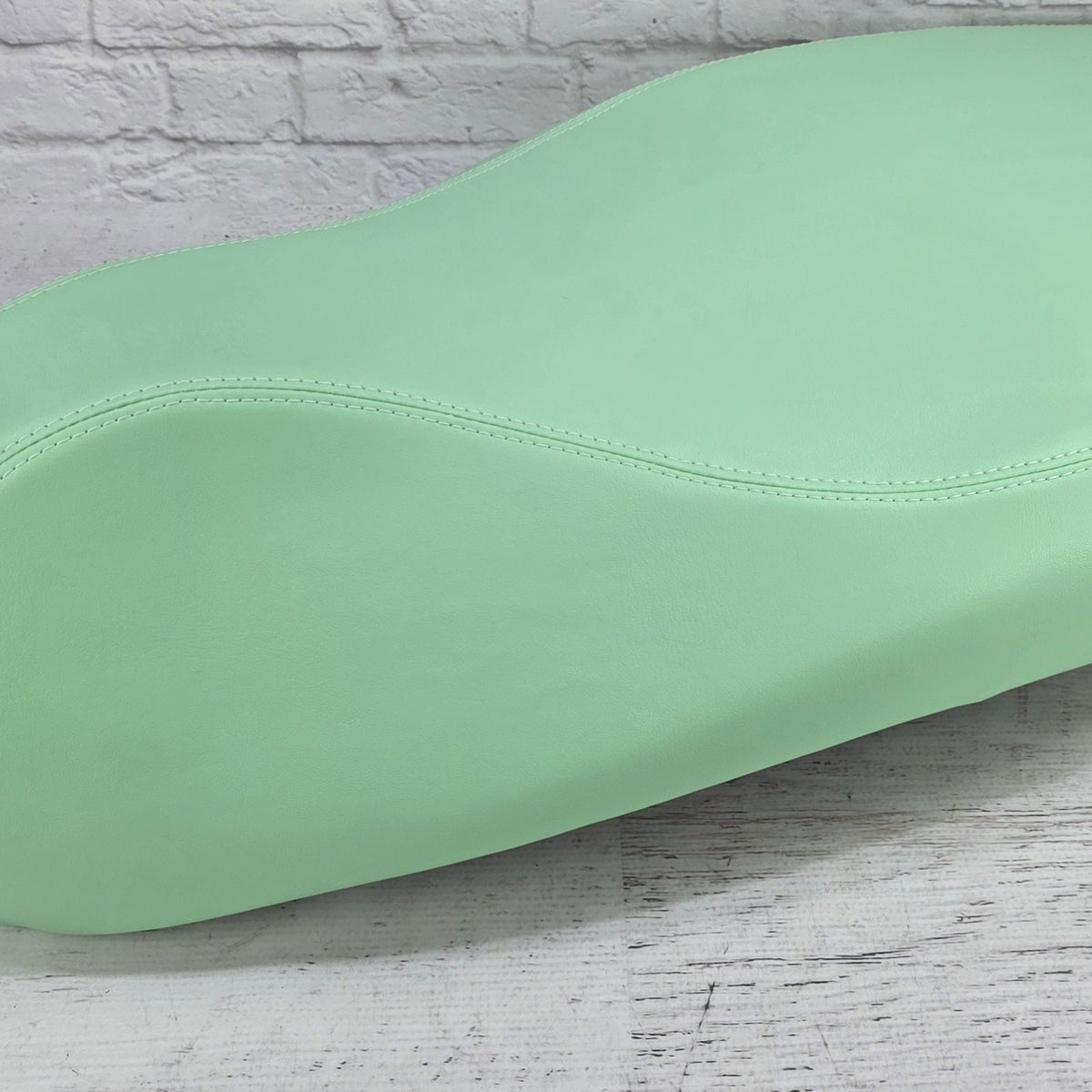 Close-up of the Lime Sherbet Vespa seat cover showing the neat double French-seam construction, handmade by Cheeky Seats.