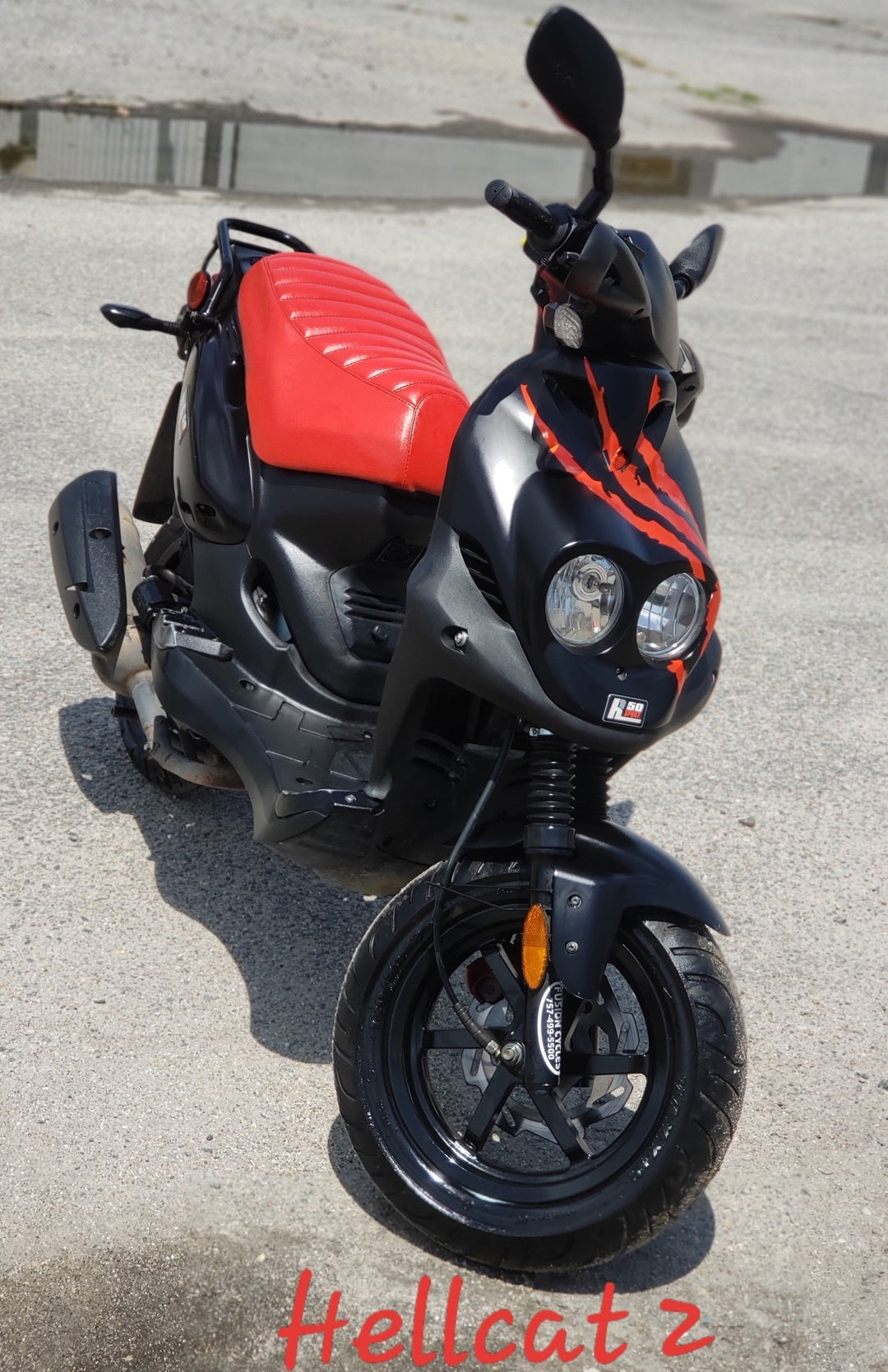 Hellcatz - a Genuine Roughhouse 50 customized scooter - wearing a red tuck and roll seat cover, handmade by Cheeky Seats