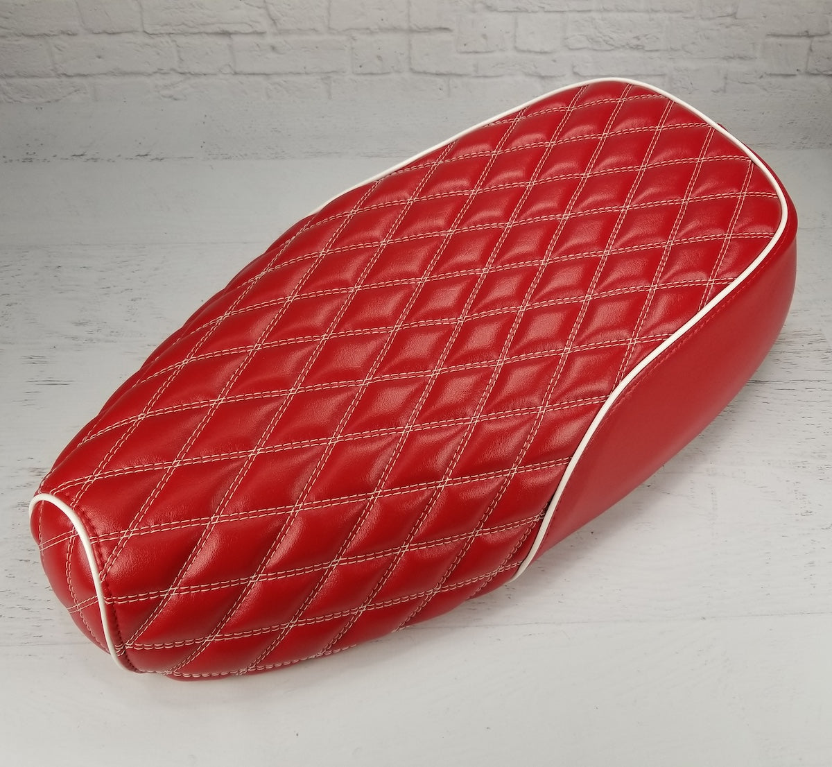 Red Genuine Buddy Kick 125 seat cover with white double-diamond stitching and white piping, handmade by Cheeky Seats