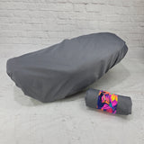 Pewter Honda DAX 125 protective seat cover with a rolled carry pouch and bright floral strap, by Cheeky Seats