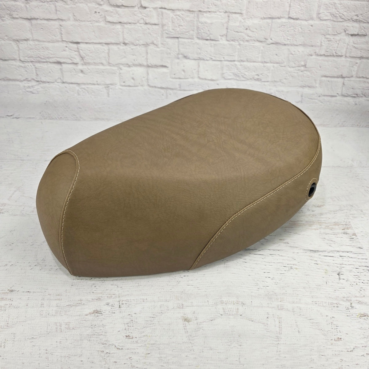 Rear three-quarter view of a café tan Kymco People 50 seat cover showing the leather-grain texture and lock opening, handmade by Cheeky Seats