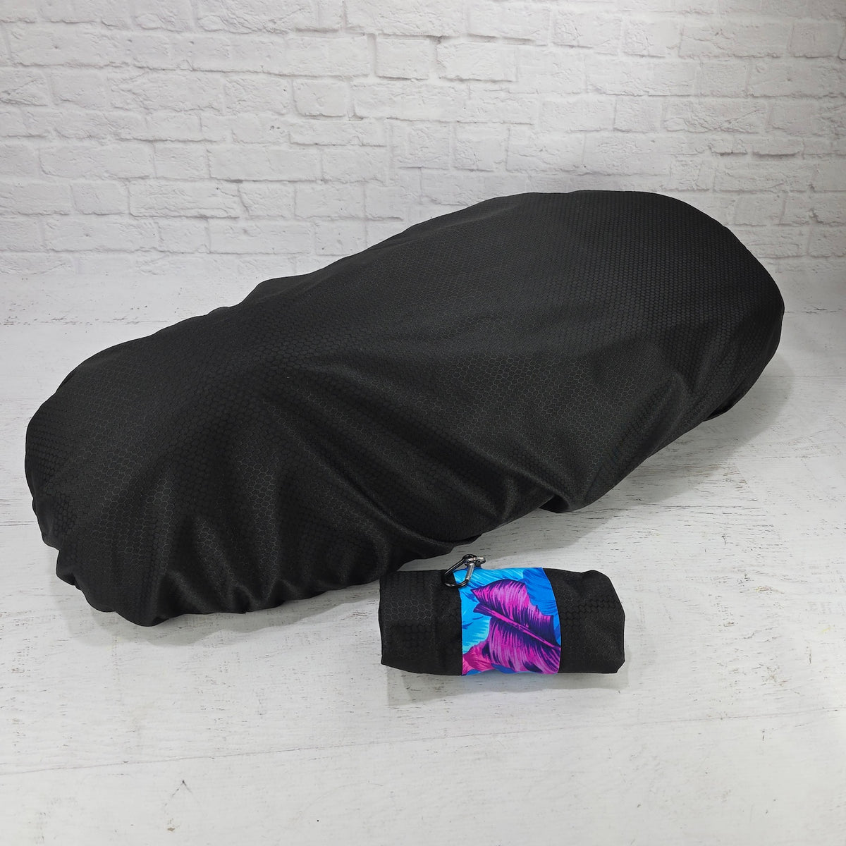 Black honeycomb rain and elements cover for Piaggio Fly and Liberty seats with a blue leaf carry pouch, by Cheeky Seats