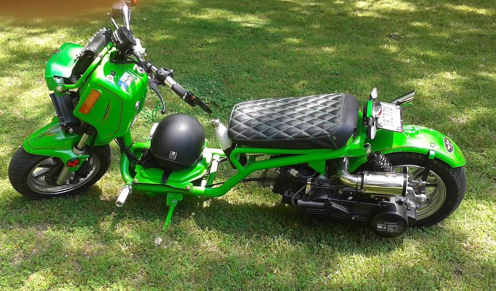 Customer photo of a green Maddog scooter on grass with a black Cheeky Seats diamond seat cover installed